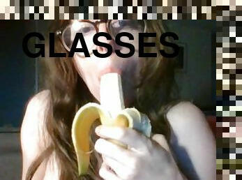 girl with cute glasses sucks banana