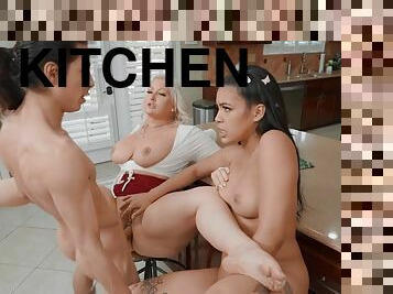 Long-haired dude fucks two passionate nymphs in the kitchen