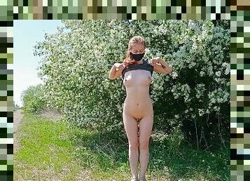 Hot teen striptease in front of a blooming tree