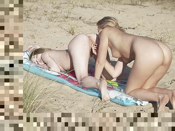 Nude lesbians share a sensual beach play together
