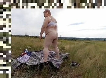 fat woman masturbates pussy with a toy in the field