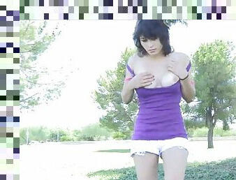 Horny teen brunette masturbates in the middle of a park