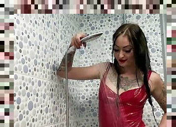 Latex fetish. Mistress Nika in a latex dress takes a shower. Watch as water drops cover Mistresss body