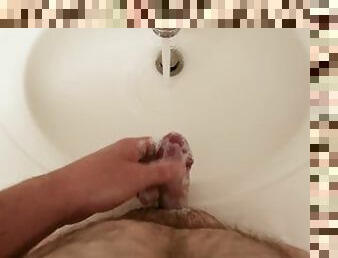 Close up while washing penis in bathroom sink using soap