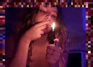 Curly haired girl smokes a late night cigarette and touches her body!